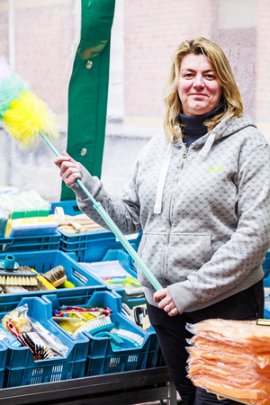 verkoopster met plumeau in haar handen verkoopster met plumeau in haar handen